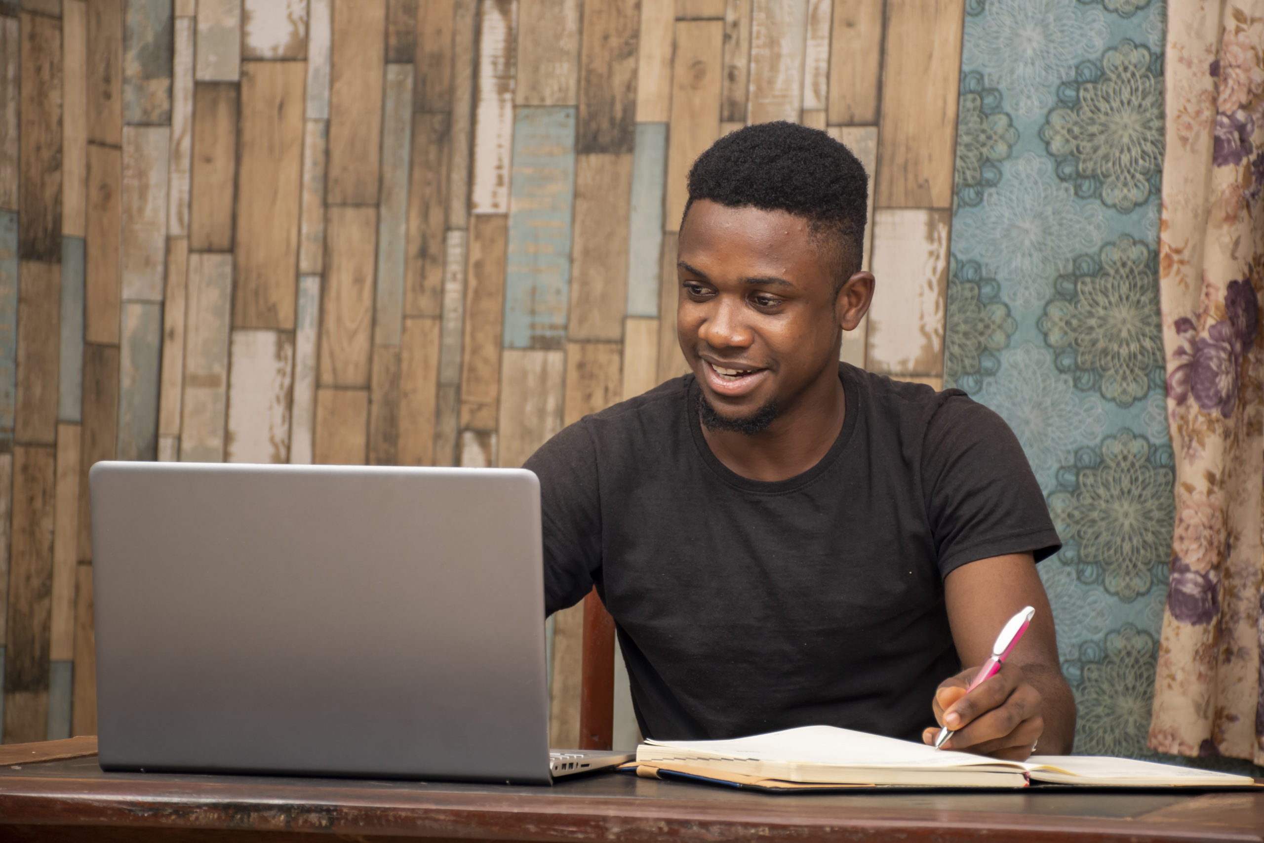 young african man studying at home using his laptop, studying